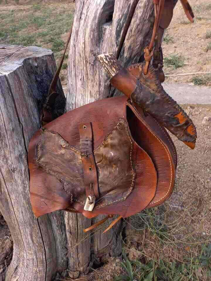 Torba i nož sa futrolom vise na drvenom panju