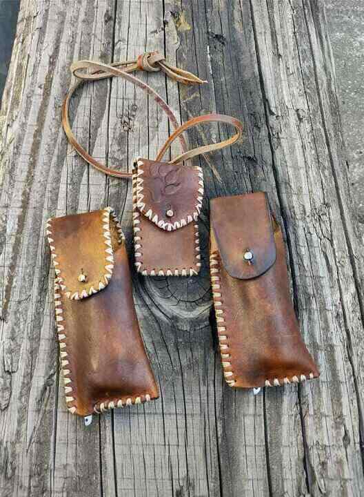 Tri kožne futrole na drvenom stolu