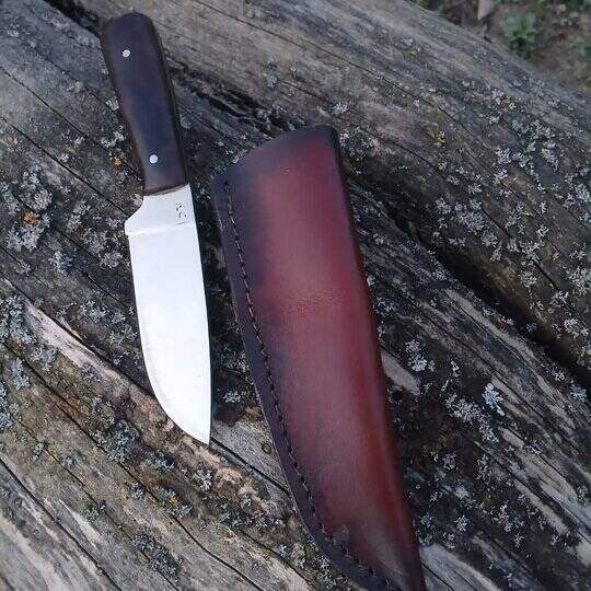 Manji nož sa braon kožnom futrolom na panju