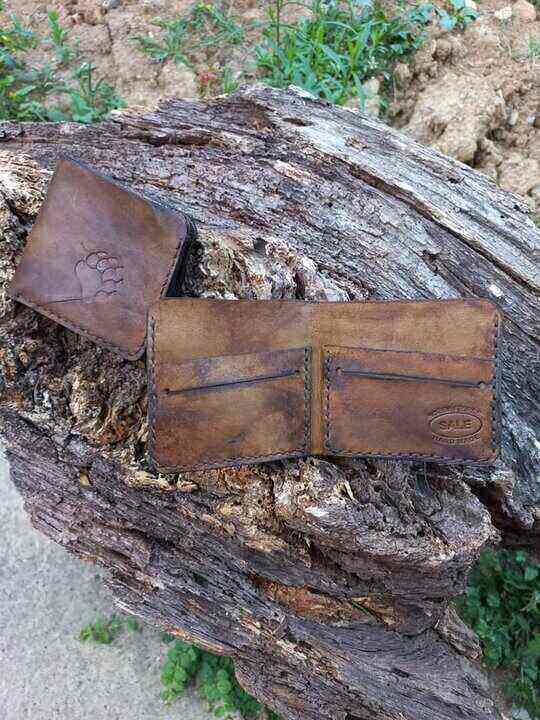 Dva gravirana kožna novčanika na panju