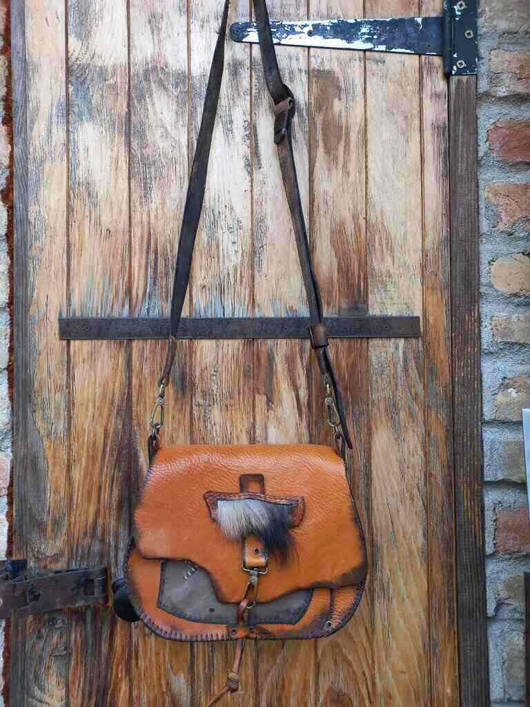 Kožna braon tašna visi na vratima